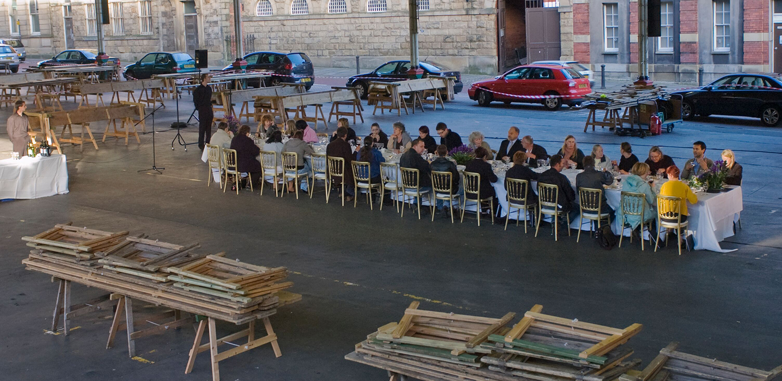 The Preston Market Mystery Project. A long table is set up in Preston market with attendees seated along either side.