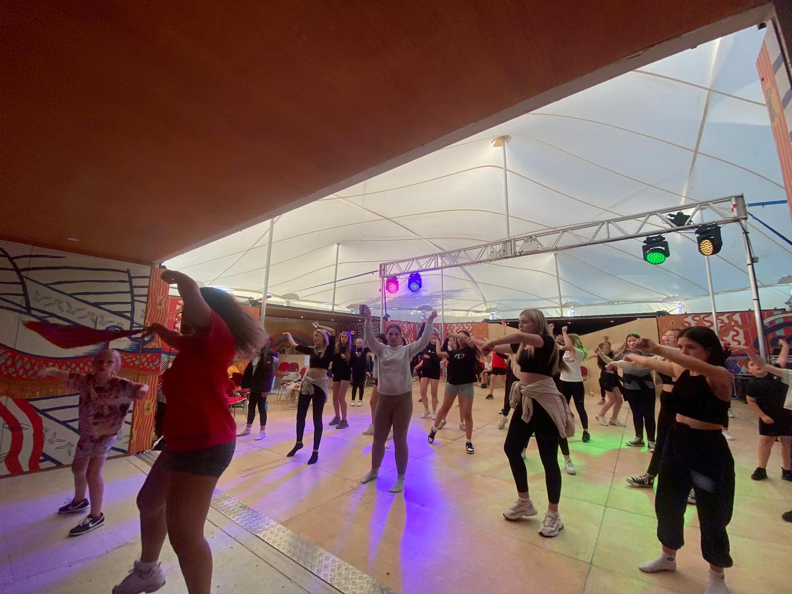 A photograph of a dance session taking place at the MET. Several young people are in the middle of a routine.