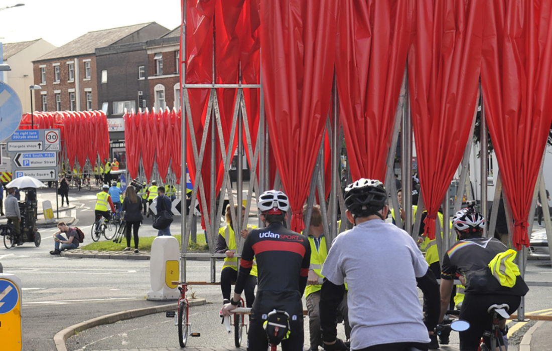 A team of volunteers in hi-viz pedal the The People's Canopy from the UCLan campus to the Harris Square in Preston