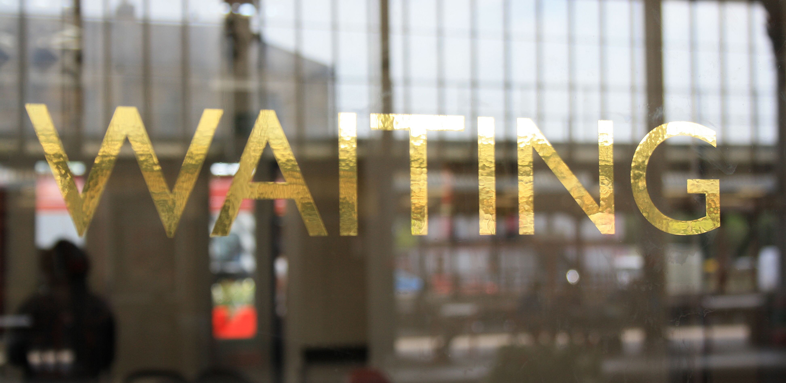 Letters on the windows of the waiting rooms of Preston train station as part of an artwork by Lisa Wigham. The word is 'waiting'
